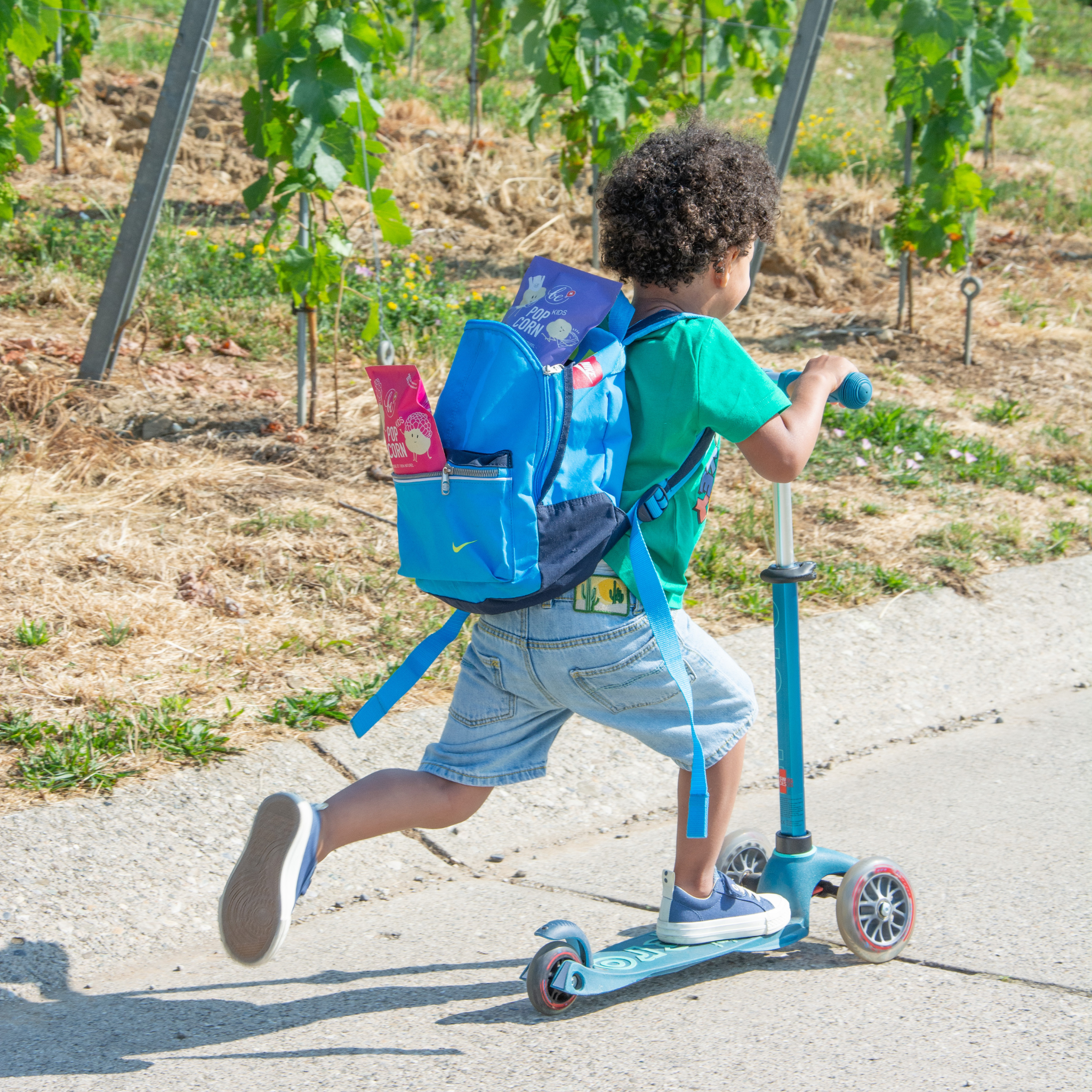 Enfant qui a les deux minis paquets de popcorn Kids dans son sac à dos